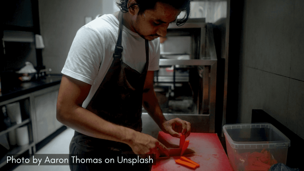 A man cutting vegetables and cooking meal