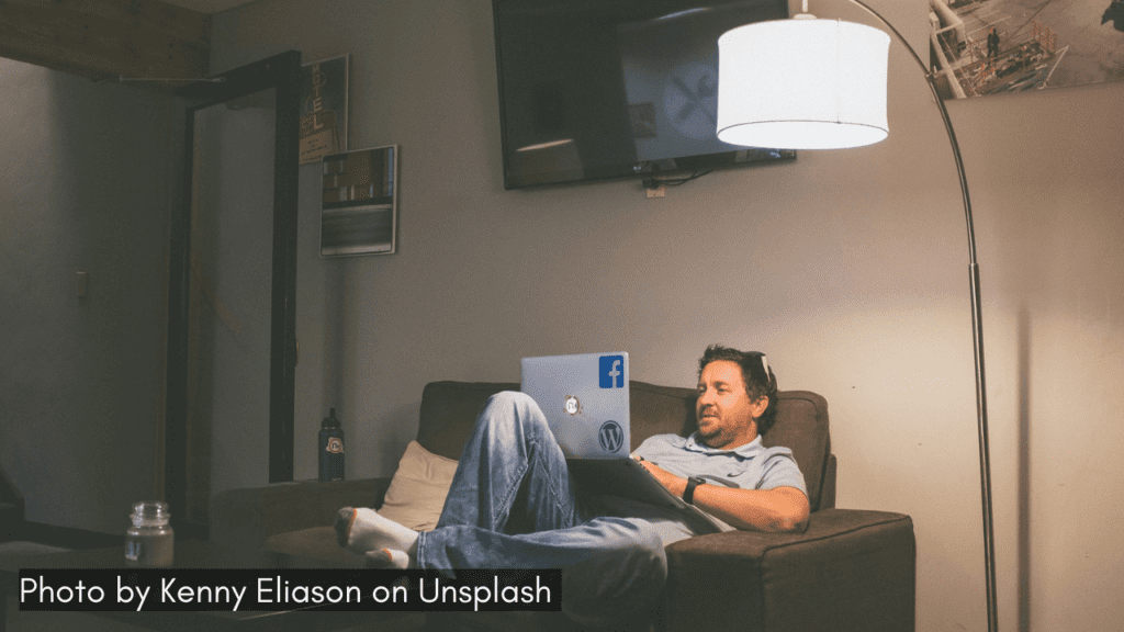 A man enjoy a rainy day watching movies on laptop