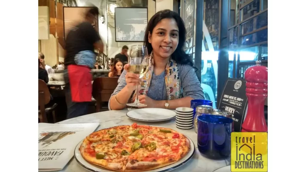 sarah enjoying pizza and white wine at PizzaExpress Mumbai