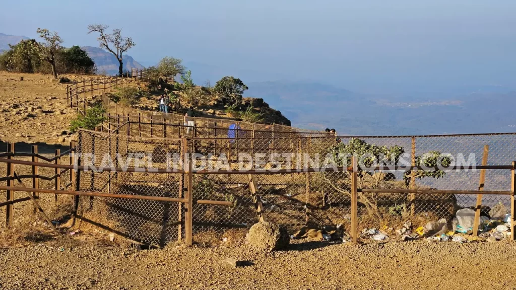 Couples at Tiger Point Lonavala beyond the barricades taking selfies and trash lying around