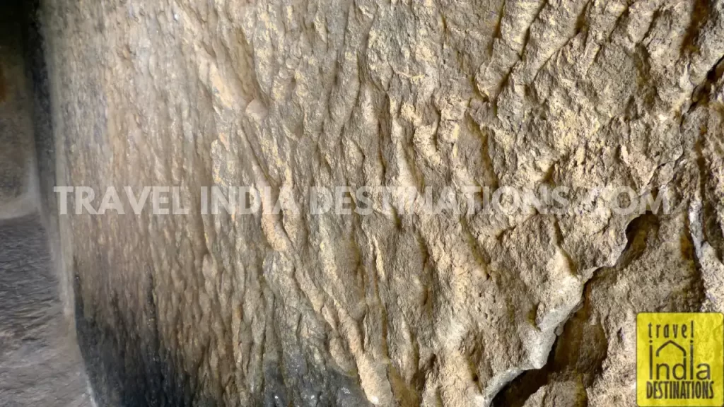 Hand-chiseled walls of Bhaja Caves, displaying the rugged, unfinished texture of the stone.
