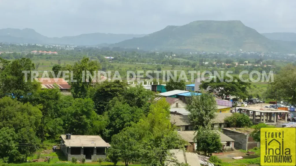 Panoramic view of Bhaje village, featuring village homes with mountains in the backdrop.