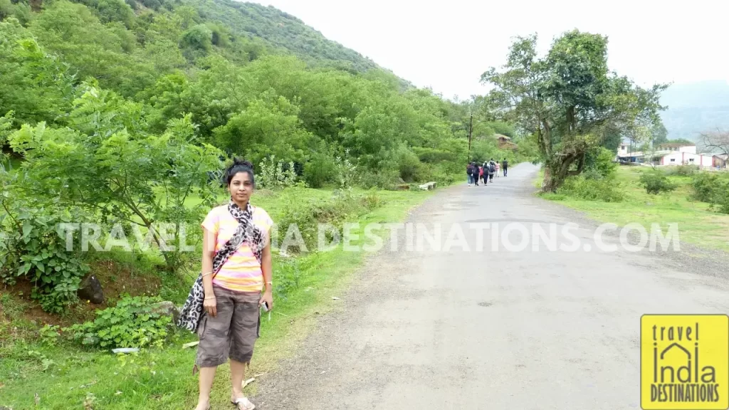 Sarah posing on the road leading to Bhaja Caves, with the village surroundings in the background.