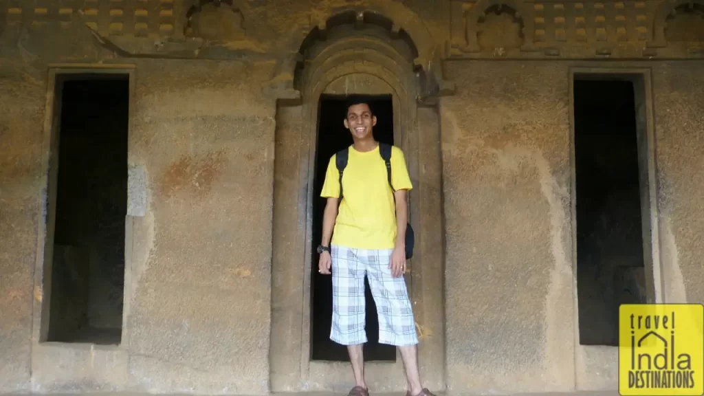 Sharukh posing outside a monk's room at Bhaja Caves, showcasing the ancient architecture.