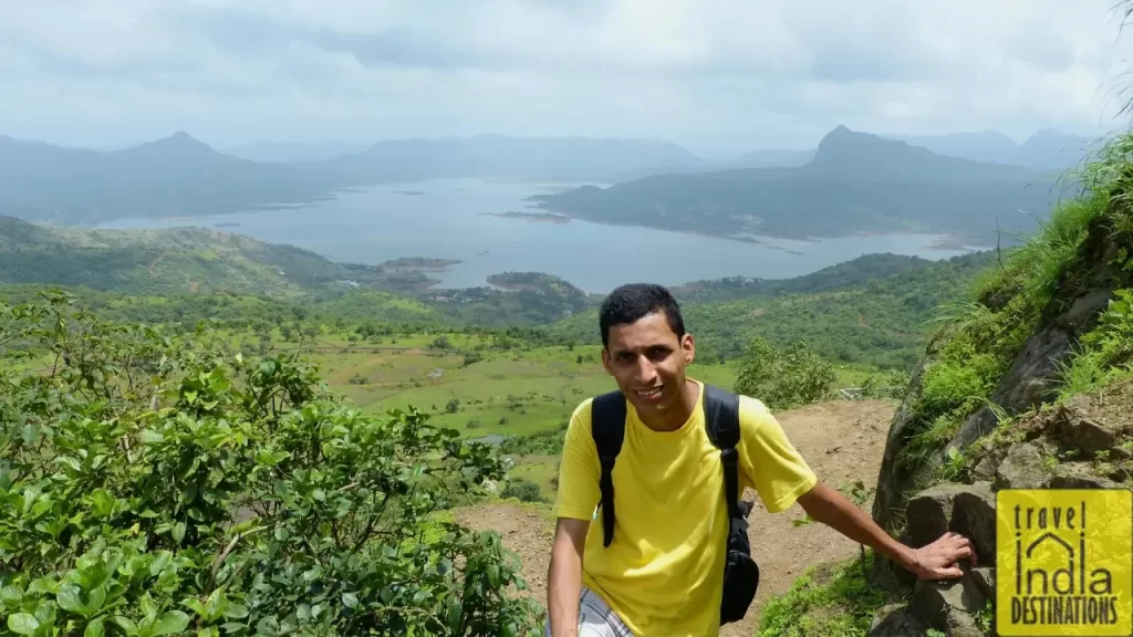 Sharukh trekking the Lohagad Fort trail with the backdrop of Pawna Lake.