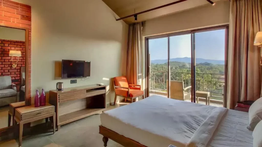 Modern bedroom at Advait Resort Kshetra Mahabaleshwar with balcony and seating area