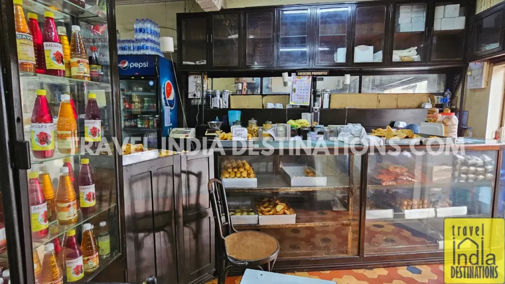 Display of freshly baked goods including Mawa cakes, syrup bottles and pastries at Merwan & Co. in Mumbai