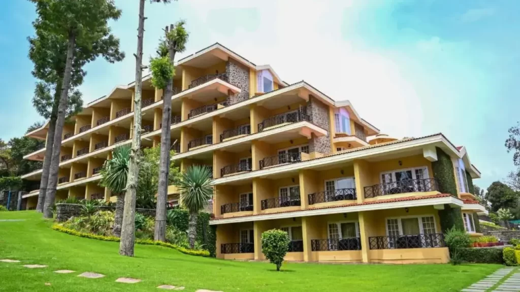 A view of Carlton Lakefront hotel in Kodaikanal with private balconies and landscaped garden.