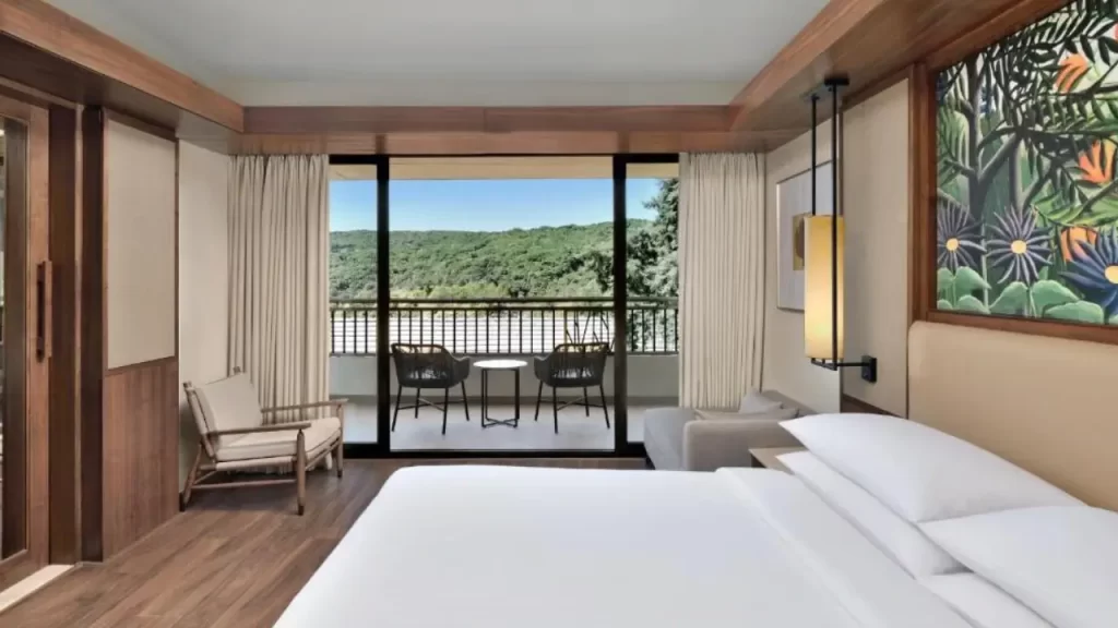 A view of king size bed and balcony room at Courtyard Marriott one of the top five star hotels in Mahabaleshwar