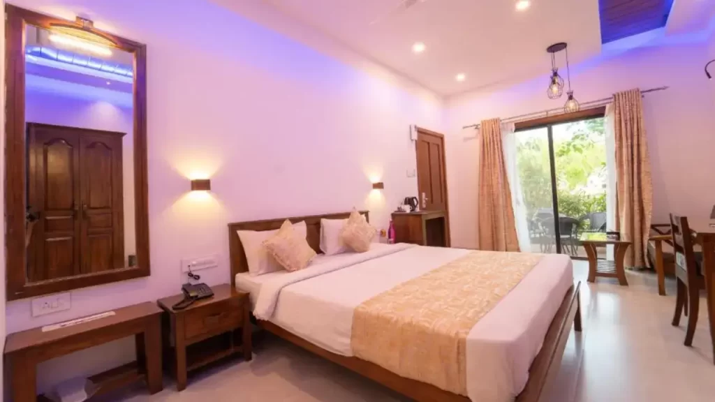 Cozy bedroom at La Serene Mahabaleshwar with balcony and flat-screen TV one of the best hotels in Mahabaleshwar