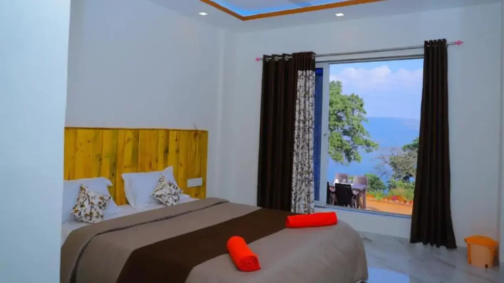 Basic room at Sai Siddhigiri Villa Mahabaleshwar with window view of surrounding hills