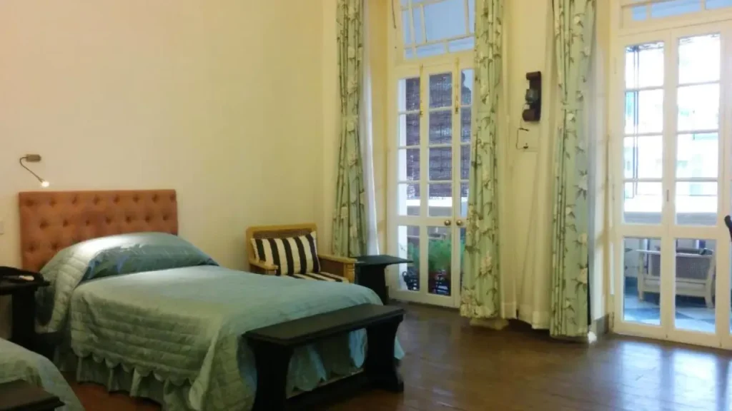 A well-lit bedroom in a Kolkata budget hotel at The Harrington Residency near Park Street.