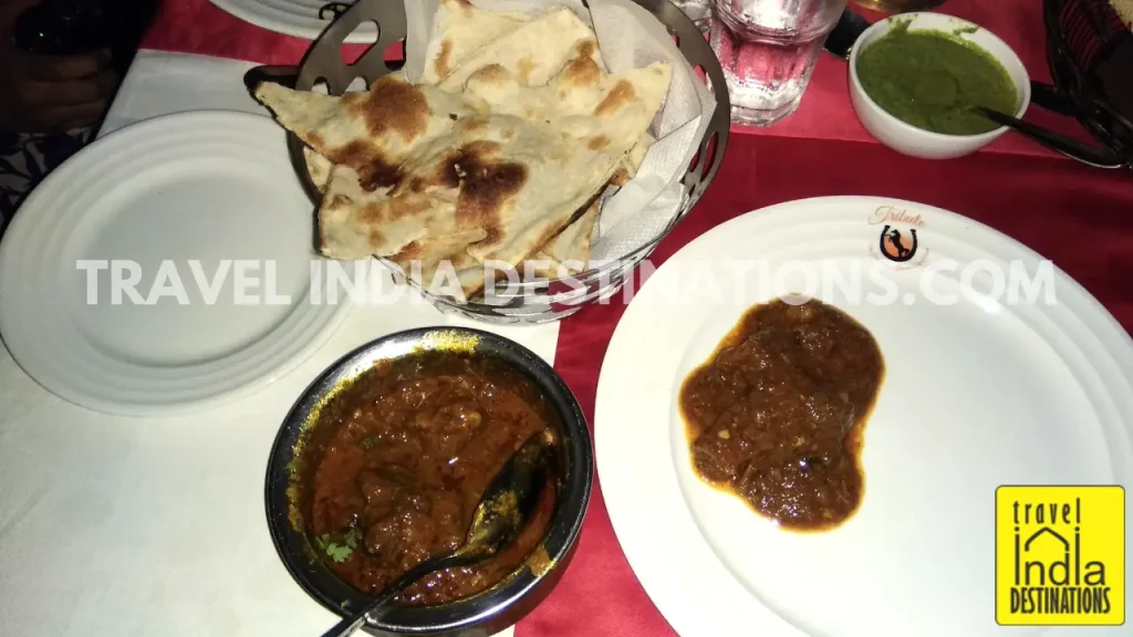 An overview image of the Laal Maas with plain naans and chutney for the starters at Tribute Restaurant Udaipur.