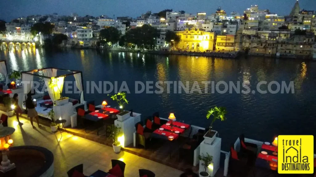 A shot of Gangaur Ghat from Upre by 1559 AD during the evening hours as lights shimmer in Lake Pichola.