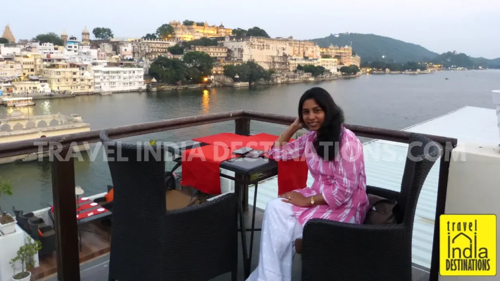 A woman enjoying the view on VIP deck of Upre by 1559 AD in Udaipur overlooking Lake Pichola and City Palace.