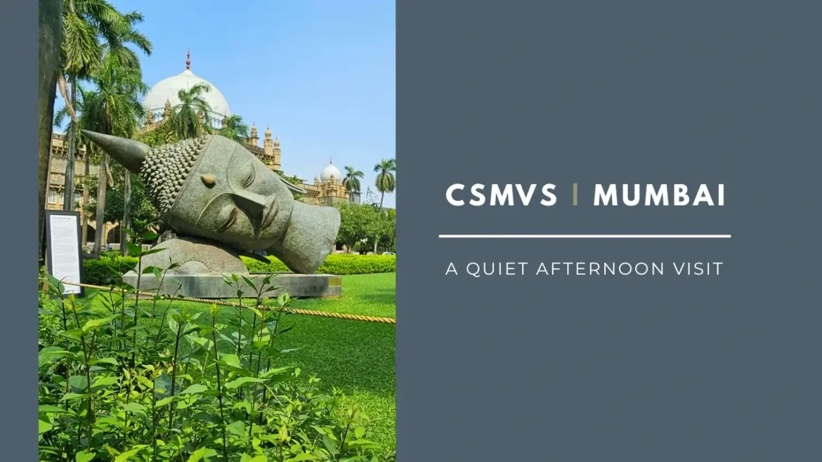 Chhatrapati Shivaji Maharaj Vastu Sangrahalaya with its white dome rising above palm trees and a giant Buddha face in the garden, framed against a clear blue sky.