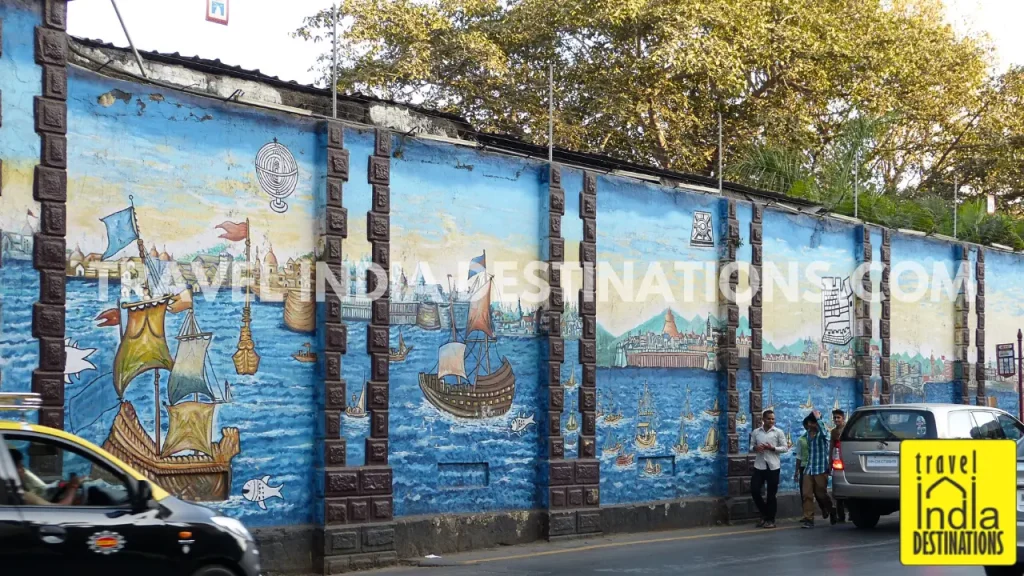 Painted mural outside Lion Gate depicting Arabian Sea, Portuguese ships, and Mumbai skyline at Kala Ghoda Arts Festival.