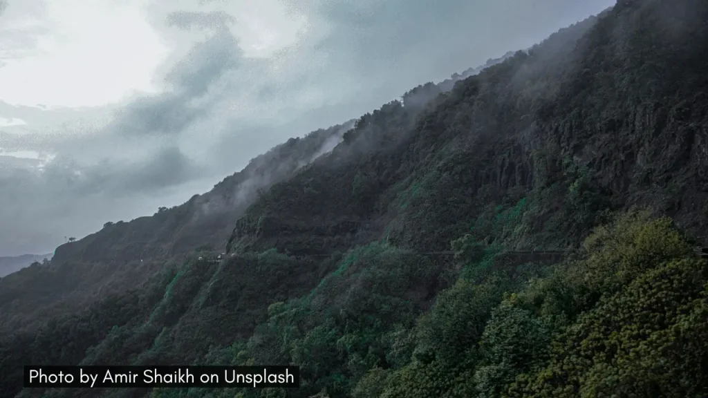 A shot of dark monsoon clouds hovering over the lush Ambenali Ghat in Maharashtra.