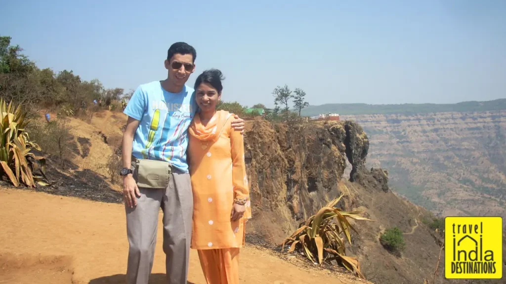 Couple on a honeymoon posing for camera with Kate's Point in Mahabaleshar in the background.