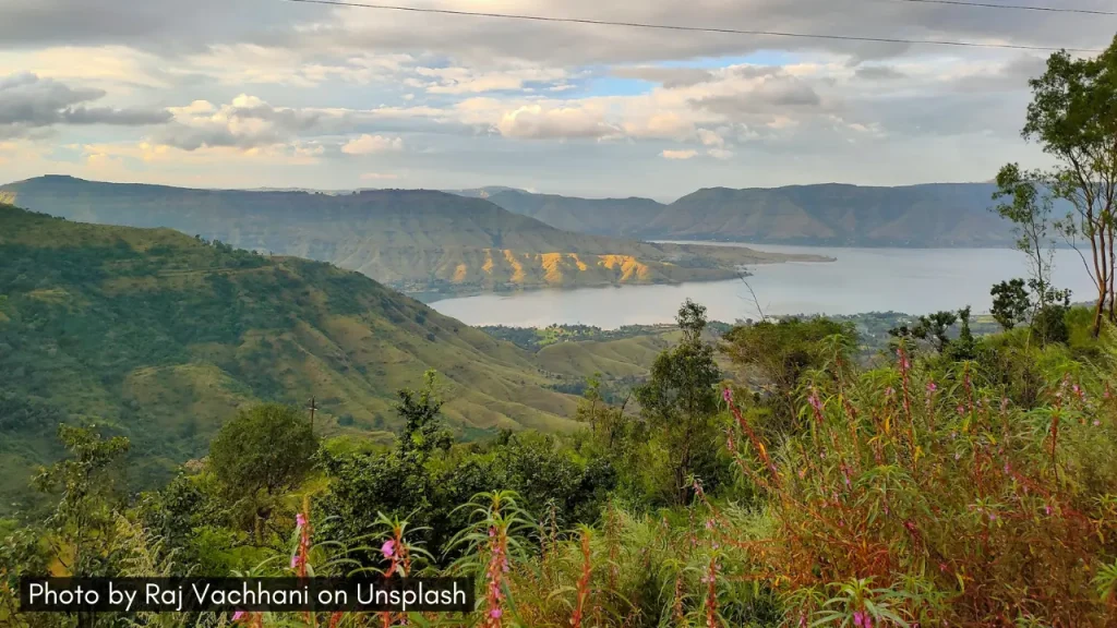 A shot of Dhom Lake with lush green landscapes and mountains in Panchgani.