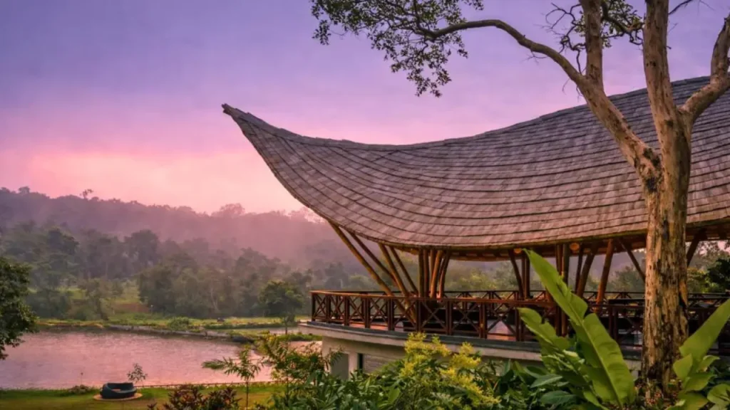 Exteriors of The Leela Coorg Forest Sanctuary with lush greenery and lake nearby, one of the best overall hotels in Coorg.