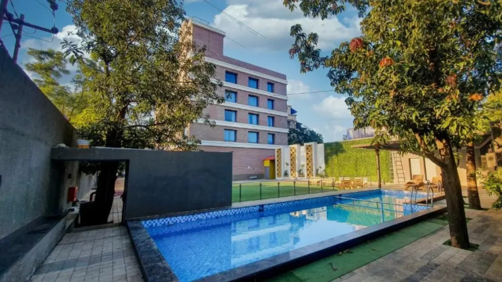Exteriors of The Orchid with outdoor swimming pool and garden area, one of the upper mid-range hotels in Lonavala.