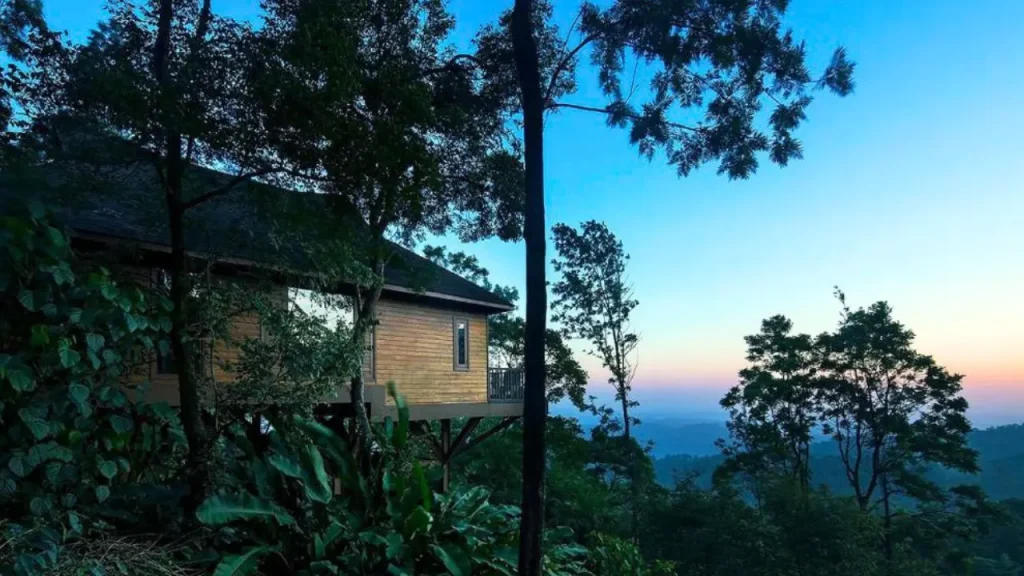 Exteriors of wooden cabin at The Tamara Coorg, one of the best hotels in Coorg surrounded by coffee estates.