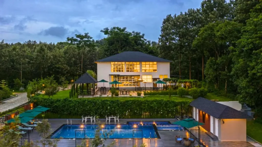 Exteriors of Vismita County Resort in Chikmagalur with outdoor swimming pool and lush coffee estate around the property.