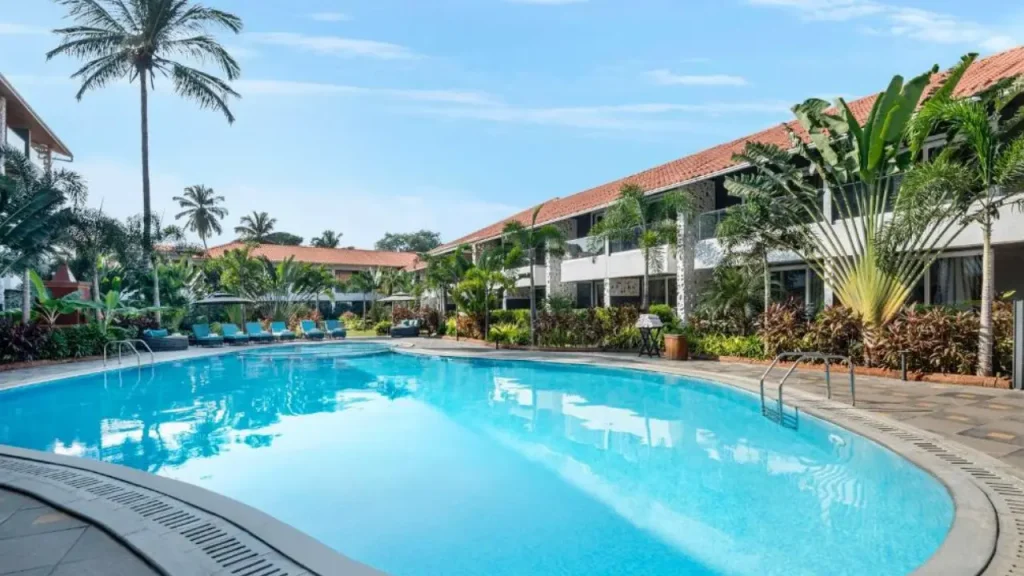 A shot of outdoor swimming pool and lush greenery at Hyatt Place Goa Candolim, one of the best affordable hotels in Goa.