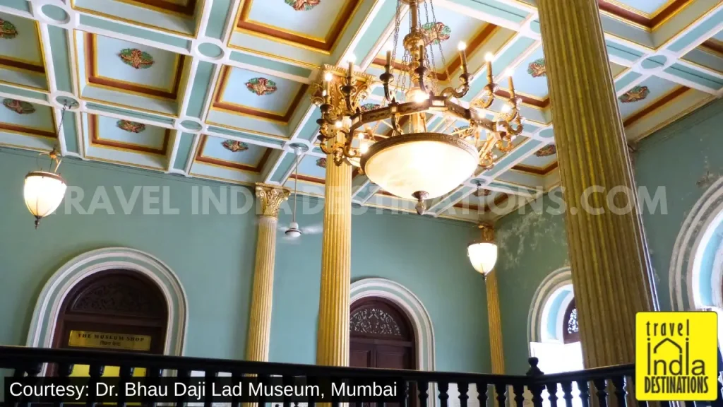 Ornate interior entrance of Dr. Bhau Daji Lad Museum with decorated ceiling, pillars and chandelier.