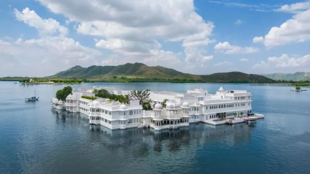 An overview of Taj Lake Palace in the midst of Lake Pichola and the surrounding Aravali hills, one of the best hotels in Udaipur.