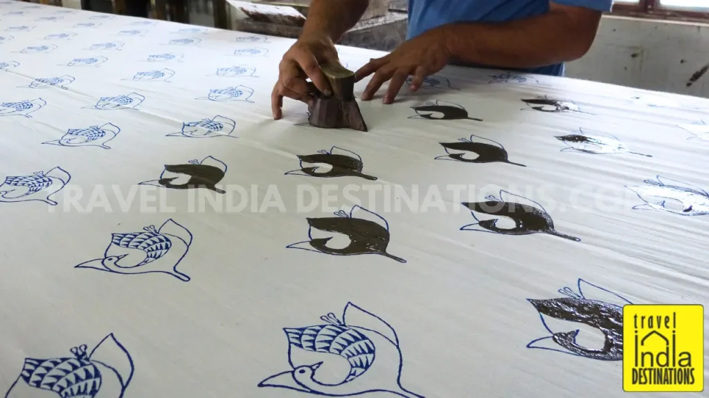 A worker pressing a Daboo print block on the fabric in a workshop in Udaipur.
